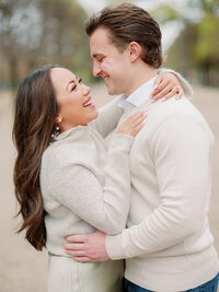 a man and woman smiling and facing each other