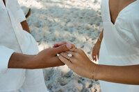 couple holding hands showing engagement ring