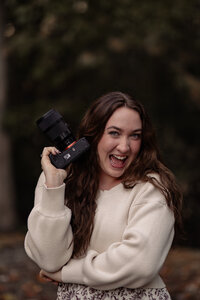 Photographer Leah Petersen holding her camera for a portrait