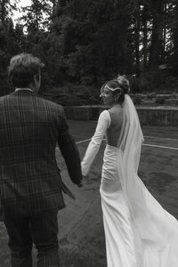 "Candid moment of a couple embracing on a tennis court on Quadra Island, captured by Vancouver Island wedding photographer Rae Terrillon