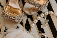 Heels and wedding jewelry laid out next to each other