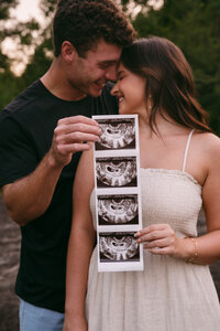 Expecting parents showing off their sonogram photos.