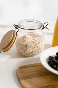 Dried oatmeal in a glass canister to showcase one of the main ingredients in Berry and Balm soap