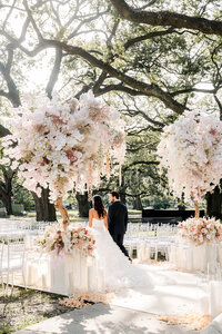Bride and groom under ceremony floral arch