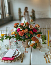 Gorgeous wedding tablescape and place setting with bright yellow, red and orange flowers for a photoshoot with tabletop centerpiece, candle holders, vases and charger plates provided for rent by Beautifully Layered Events in Milwaukee, WI.