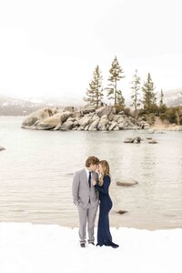 couple hugging on snowy lakeside