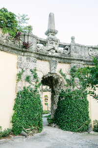 Ivy-clad stone archway at Vizcaya Museum & Gardens in Miami—elegant wedding venue captured by luxury wedding photographer Amia Marcell.