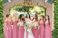 bridesmaids smiling at bride holding her bouquet