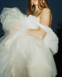 bride sitting on the ground with bouquet