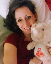 Crystal Cavitt, professional cuddler, cuddling with a stuffed elephant. Crystal practices currently at Thrive on Health