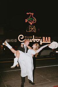 Married couple in front of Million Dollar Cowboy bar after dark in Jackson Hole Wyoming