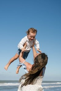 Mom holding up child taken by florida engagement photographers, Shelby Ann Photos