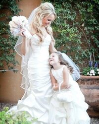 Kaylee as a little girl with her mom who is the bride in a wedding dress.