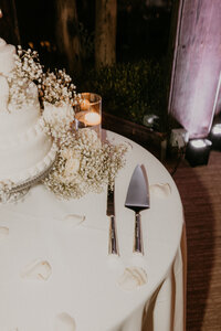 Elegant wedding cake table with candles and floral details styled by Beyond the Event, captured by Kellie Jane Photography in Southern California.