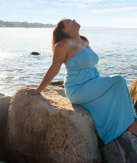 Jackie, wearing a blue dress, on the beach
