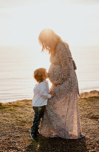 Son kissing mom's pregnant belly at Sunset Cliffs San Diego - Pregnancy photoshoot inspiration