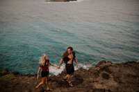 couple holding hands by ocean