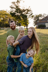 Parents playing with their kids and smiling in their yard