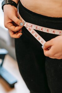 Woman measuring her hips with a tape measure