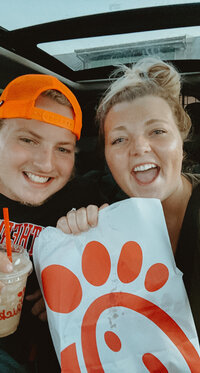 man and woman smiling while holding Chikfila bag