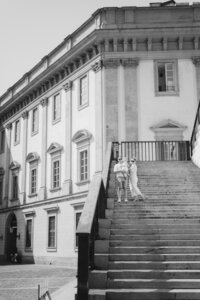 Black and white image of a family on the stairs of a European building in Venice, Italy