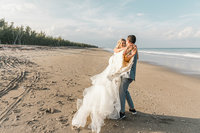 bride & groom standing on beach