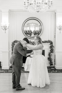 groom kissing bride's hand classic black and white photo