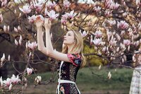 beautiful senior girl picking pink flowers off of a tree