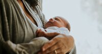 A woman holds a newborn baby.