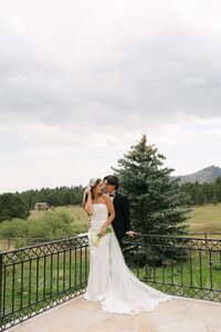 destination wedding couple leaning against railing at Greystone Castle