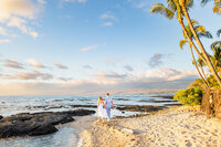 couple walking on the sand y beach and tidepools at sunset