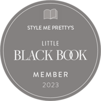 A round, gray badge with the text "Style Me Pretty's Little Black Book Member 2023" and an image of an open book icon at the top, highlighting excellence in Calgary wedding planning.