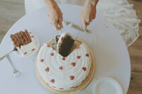 tiny heart themed wedding cake being cut