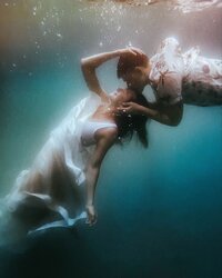 underwater bridal photo of couple kissing