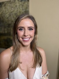 Bride with blue eyes wearing makeup in white tank top