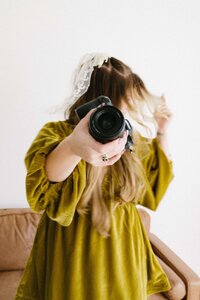 The girl holds a camera and shakes her head from side to side