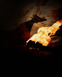 a cave drawing from the caves at lascaux france is illuminated by a burning hand-held torch