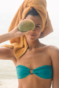 Women holding a mango in a bikini