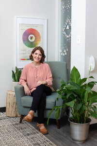 Woman seated in comfortable chair with color wheel behind her