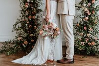 Couple embracing, showcasing flowers in bouquet.