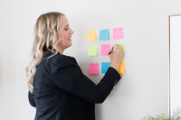 Becca writing on post it notes on a wall