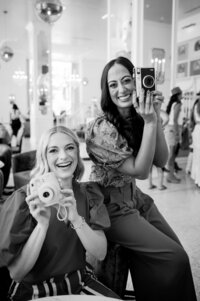 Dr. Brooks and Dr. Templeton, orthodontists in Nashville, TN holding up vintage cameras in black and white