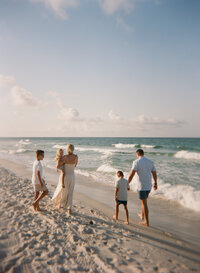 photo of a family of 5 walking together at the beach