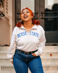 Model wearing Boise State white half zip pullover with blue letters