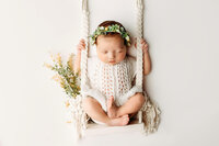 Airy newborn photograph with gentle highlights, minimal styling, and soft neutrals for a modern fine-art look.