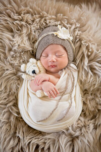 Newborn baby cuddling a teddybear