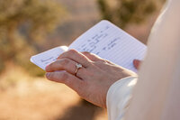 A couple standing at the edge of the Grand Canyon during their elopement, capturing a moment of love in the vast desert landscape.