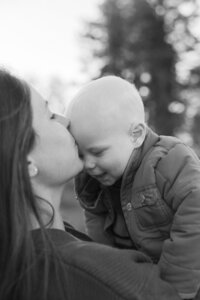 Mother kisses baby son's forehead
