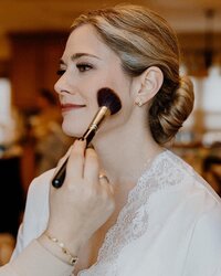 bride getting blush put on her cheek