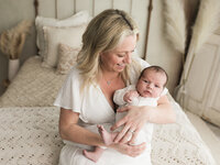 mom holding newborn baby boy for studio photoshoot
